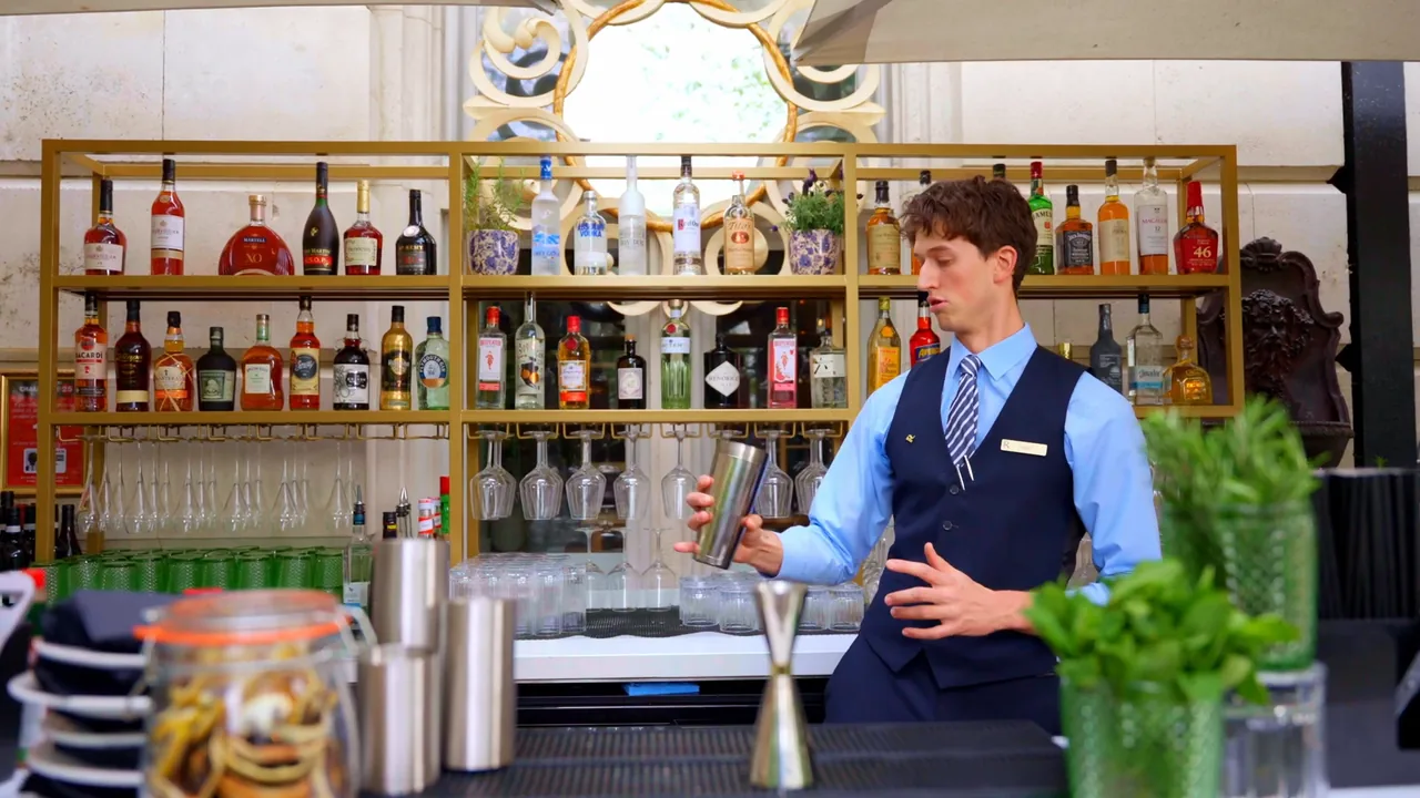 A bartender shaking a cocktail at the garden bar of a networking event at The Royal Horseguards Hotel, Whitehall — a still from our film
