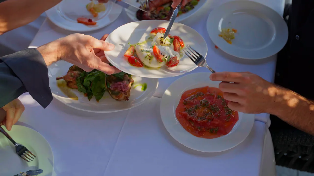 Dishes being shared at the table at Solaya, art'otel London Hoxton — a still from our film